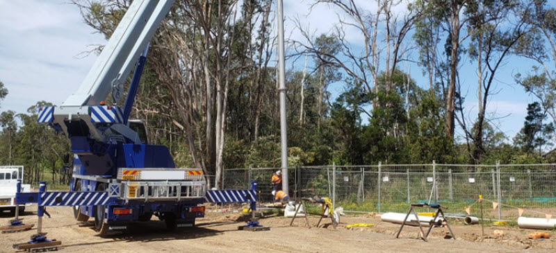 Blue crane lifting a sewer vent